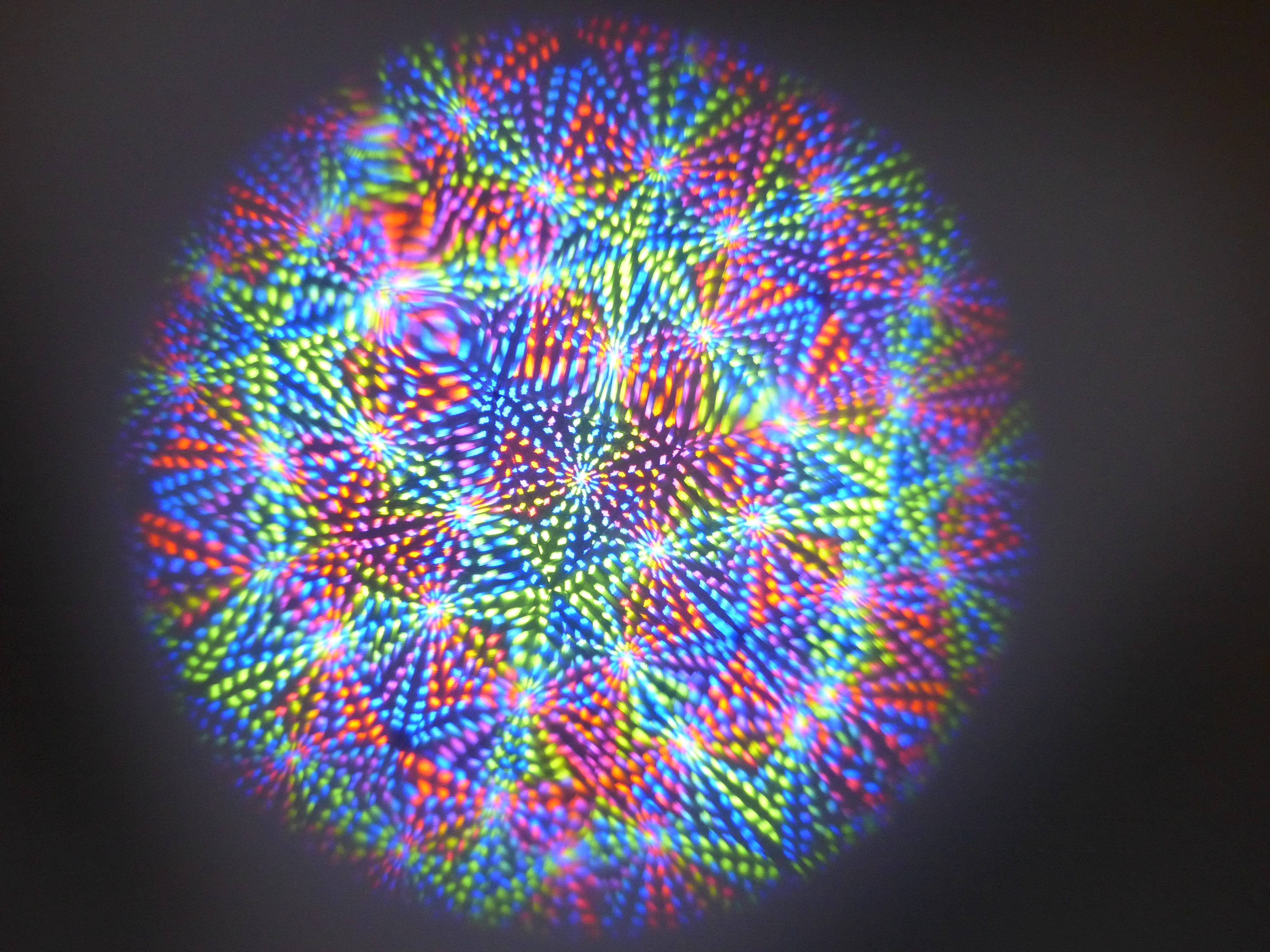 A colourful radial kaleidoscope pattern seen through the eyepiece