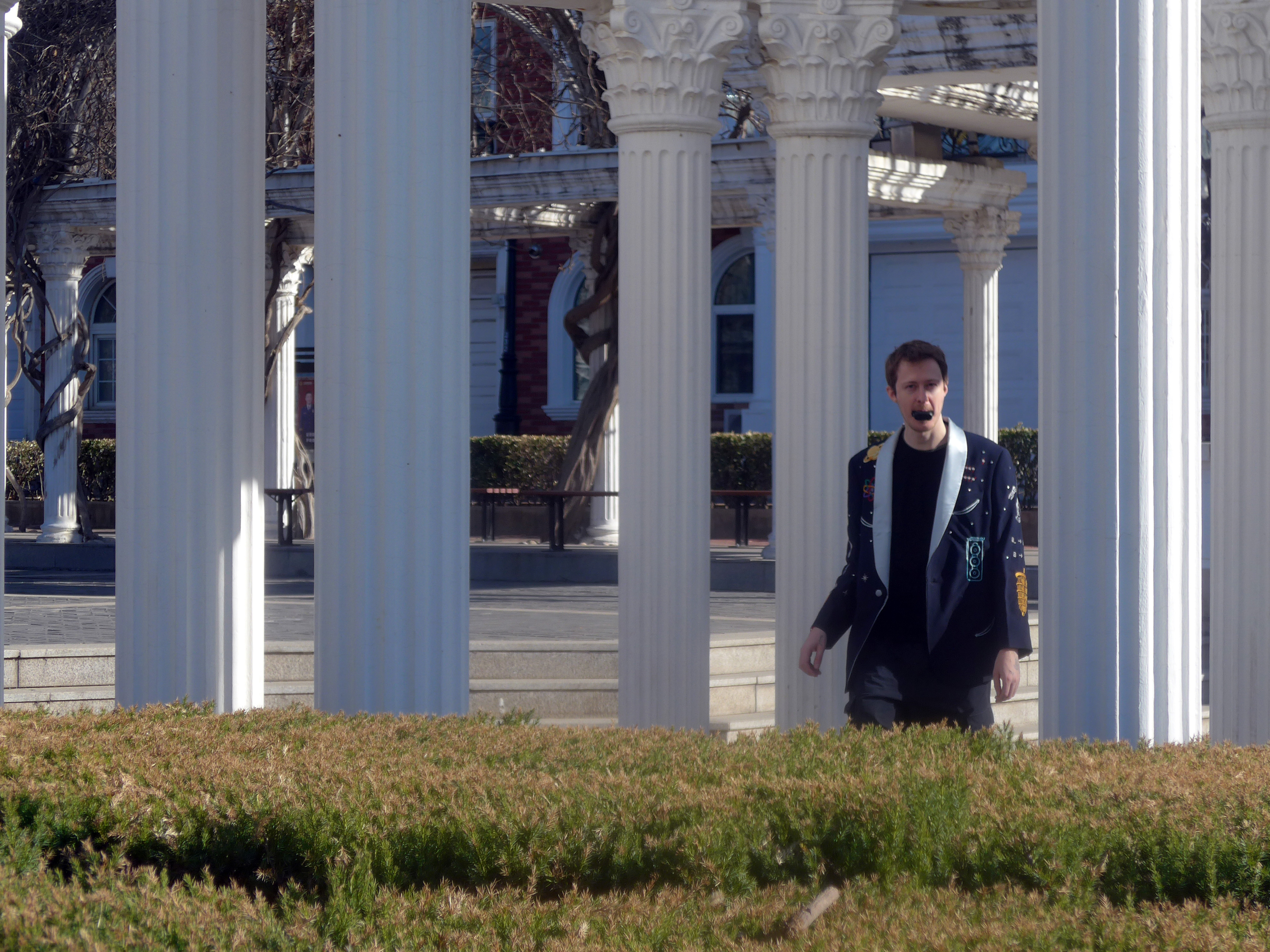 Wearing the jacket with an action camera held in the mouth, walking between columns