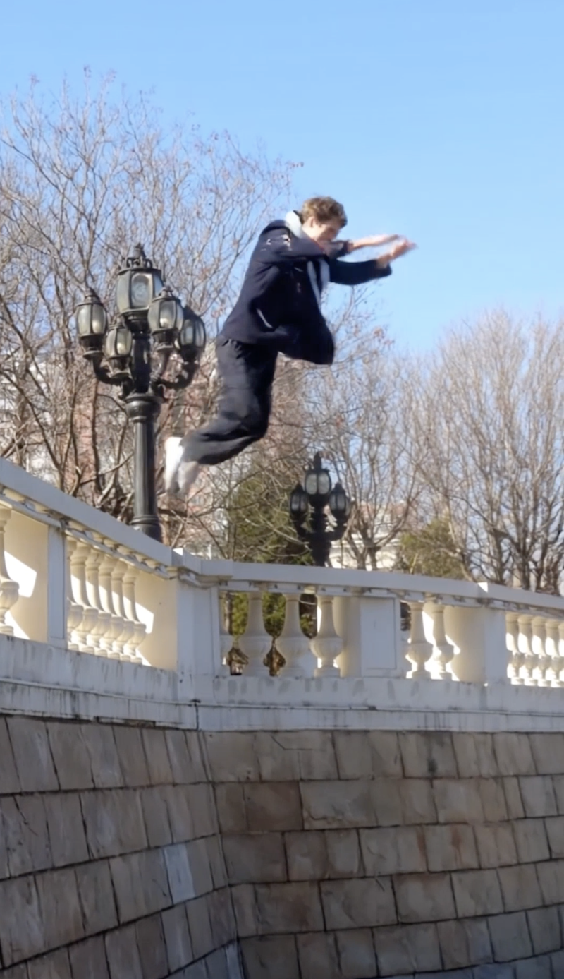 Mid-jump off the balustrade in the jacket